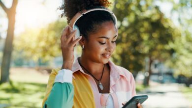 Person listening to music on headphones while using a smartphone